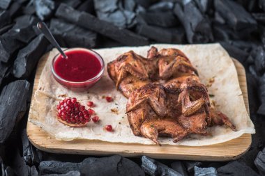 Nar soslu kavrulmuş tavuklar tahta tahtada servis edilir