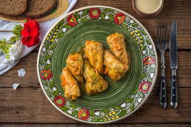 Ahşap masa üzerinde rustik çiçek desenli plaka üzerinde geleneksel lahana rulo