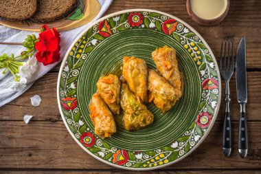 Ahşap masada desenli rustik plaka üzerinde et ile biber dolması