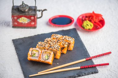 Japon Suşi roll kayrak üzerinde çubuklarla hizmet.