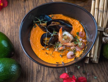 Tay deniz ürünleri ve malzemelerle ahşap masa kase sebze çorbası krem