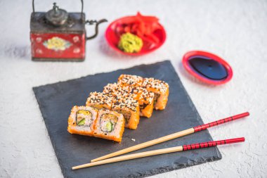 Japon Suşi roll kayrak üzerinde çubuklarla hizmet.