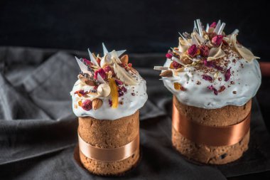 Lezzetli yakından görmek Paskalya çiçekler ile kek pişmiş, şekerlenmiş meyve ve çikolata koyu arka plan üzerinde