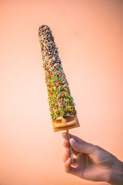 tatlı şeker ve çikolata Stick bej renkli arka plan üzerinde gözleme tutan insan el kaplı