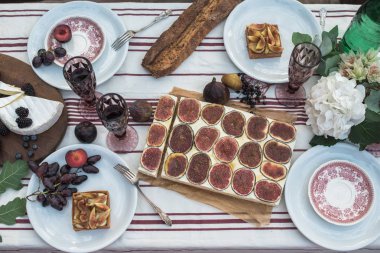 lezzetli tatlılar, meyveler, çilek, gurme pasta ve çiçekler bahçesinde şenlikli tabloyla Üstten Görünüm