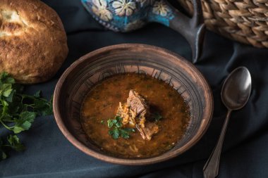 Siyah masa örtüsü üzerinde kil kase et ile sebze çorbası
