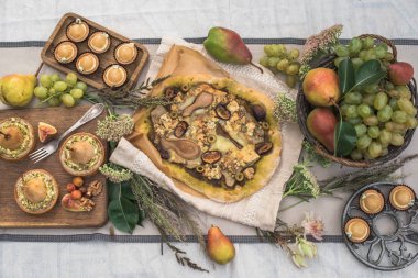 bahçede şenlikli masaya lezzetli kekler, pizza, armut ve meyve ile tartlets Üstten Görünüm