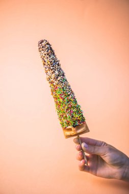 tatlı şeker ve çikolata Stick bej renkli arka plan üzerinde gözleme tutan insan el kaplı