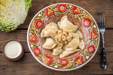 köfte lahana ve ekşi krema ile renkli plaka üstten görünüm rustik ahşap tablo 