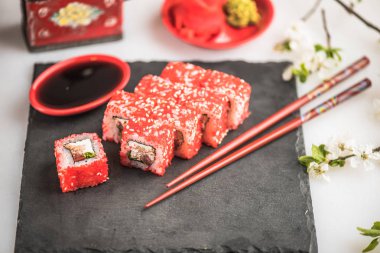 Japon Suşi roll kayrak üzerinde çubuklarla hizmet.