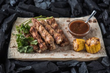 Ahşap tahta üzerinde sos ve mısır koçan ile ızgara sosis