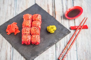 Japon Suşi roll kayrak üzerinde çubuklarla hizmet.