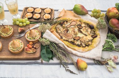 lezzetli pizza, armut, kek ve meyve bahçesinde şenlikli masaya tartlets