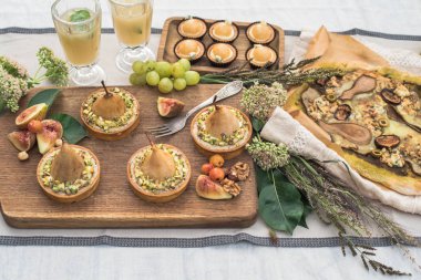 lezzetli kek, pizza, armut ve meyve bahçesinde şenlikli masaya tartlets