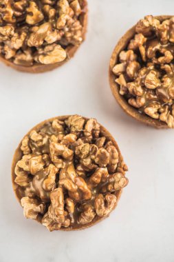 Ev yapımı tatlılar şeker karamel ve beyaz zemin üzerine ceviz ile