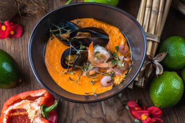 Tay deniz ürünleri ve malzemelerle ahşap masa kase sebze çorbası krem