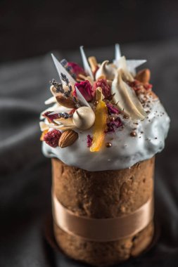 Çiçekler, şekerlenmiş meyve ve çikolata koyu arka plan üzerinde ile lezzetli Paskalya kek