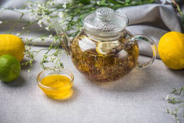 Çaydanlık ve sağlıklı bitkisel çay fincan gri masa örtüsü üzerinde servis