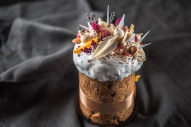 Lezzetli tatlı Paskalya kek çiçeklerle şekerlenmiş meyve ve çikolata koyu arka plan üzerinde