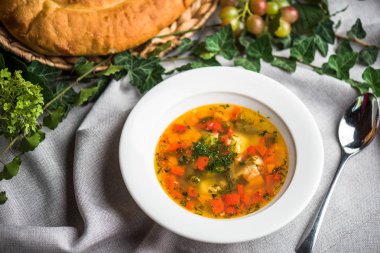 Ekmek ile masa örtüsü üzerinde plaka ev yapımı sebze çorbası