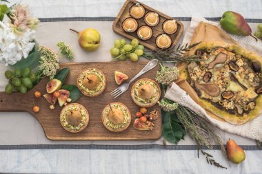 bahçede şenlikli masaya lezzetli kekler, pizza, armut ve meyve ile tartlets Üstten Görünüm