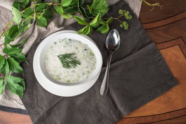 Gri peçete üzerinde kase otlar ile sebze krem çorbası