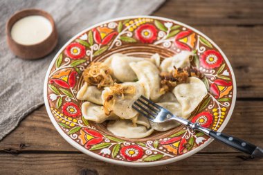 Renkli plaka ve ekşi krema rustik ahşap masa üzerinde köfte 