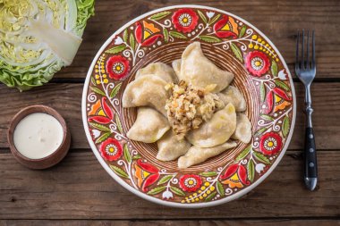 köfte lahana ve ekşi krema renkli plaka ile üstten görünüm ahşap tablo 