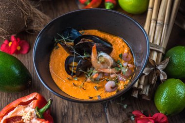 Tay deniz ürünleri ve malzemelerle ahşap masa kase sebze çorbası krem