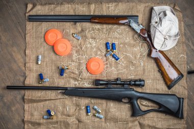 ahşap arka plan üzerinde çuval bezi üzerinde silah ve mermi
