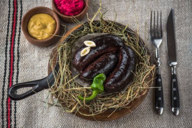 Tavada saman rustik keten kumaş üzerine süslenmiş siyah sosis