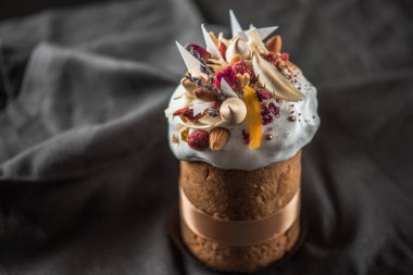 Çiçekler, şekerlenmiş meyve ve çikolata koyu arka plan üzerinde ile lezzetli Paskalya kek