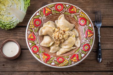 köfte lahana ve ekşi krema ile renkli plaka üstten görünüm rustik ahşap tablo  