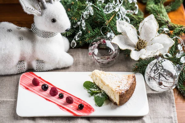 Pezzo Torta Sul Piatto Con Decorazioni Natalizie Sullo Sfondo — Foto Stock