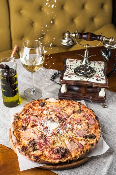 gourmet pizza and glass of wine on table in restaurant