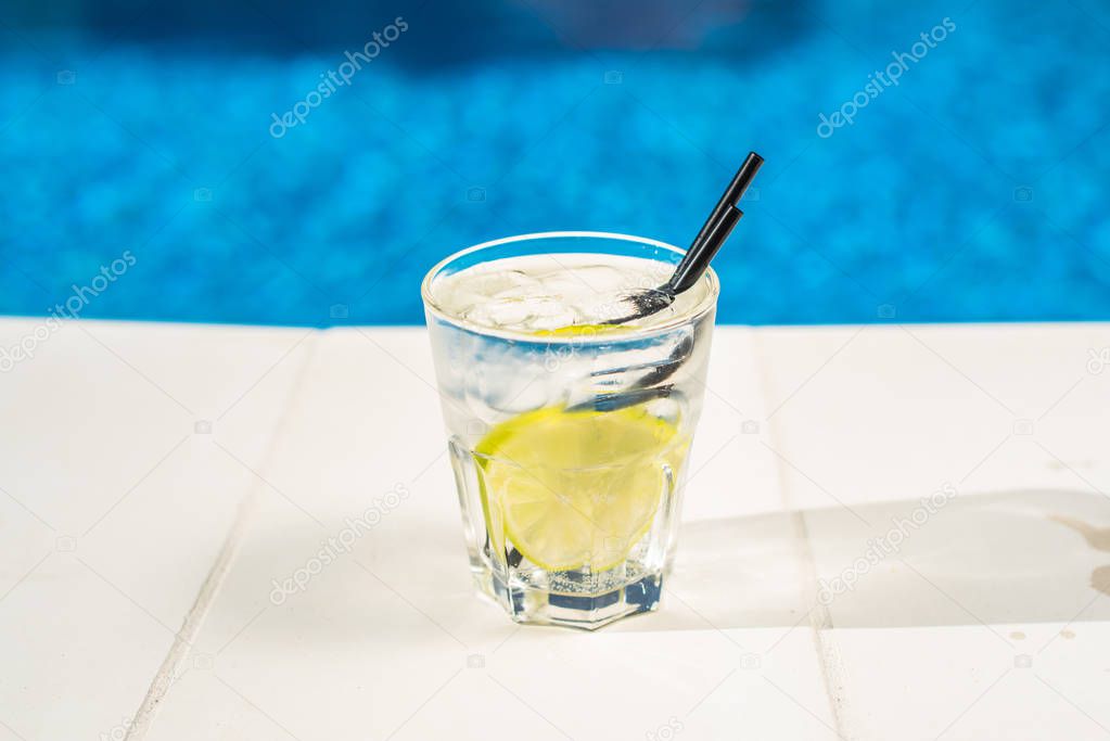 closeup of cocktail in glass placed on poolside