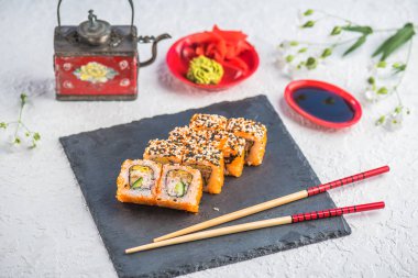 Japon Suşi roll kayrak üzerinde çubuklarla hizmet.