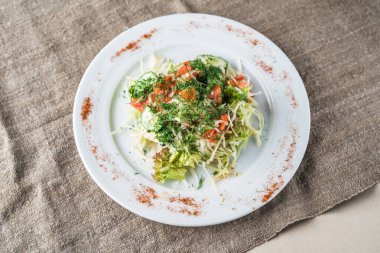 Gri keten masa örtüsü üzerinde plaka üzerinde taze sebze salatası