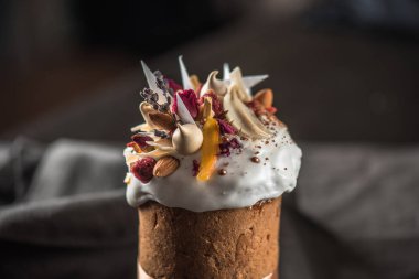 Çiçekler, şekerlenmiş meyve ve çikolata koyu arka plan üzerinde ile lezzetli Paskalya kek