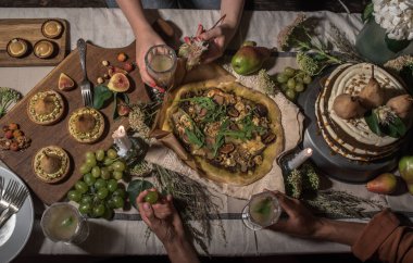 insanların şenlikli masada pizza, kek, meyve ve Bahçe içecekler ile kısmi Üstten Görünüm