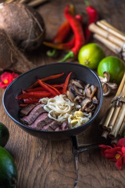 Ahşap masa üzerinde siyah kase Vietnamca Pho çorbası