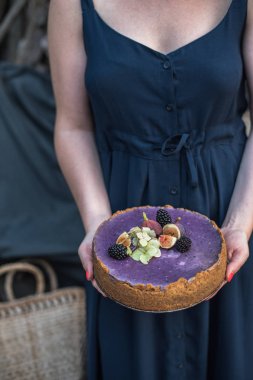 genç kadının lezzetli şenlikli kek çilek ile tutarak kısmi görünümü   