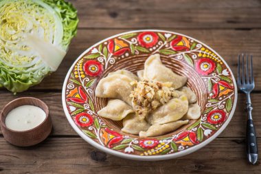 Köfte lahana ve ekşi krema rustik ahşap masa üzerinde renkli plaka