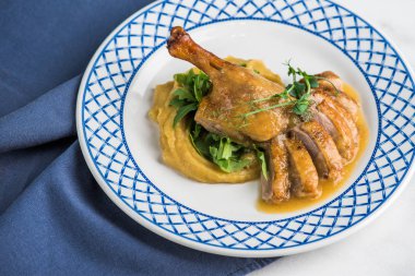 Tabak üzerinde mavi desenli plaka üzerinde patates püresi üzerinde kavrulmuş tavuk