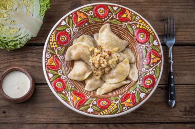 köfte lahana ve ekşi krema ile renkli plaka üstten görünüm rustik ahşap tablo  