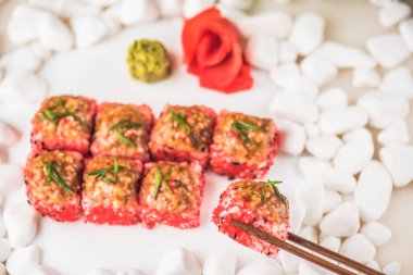 Çakıl taşları beyaz zemin üzerine Japon Suşi roll hizmet