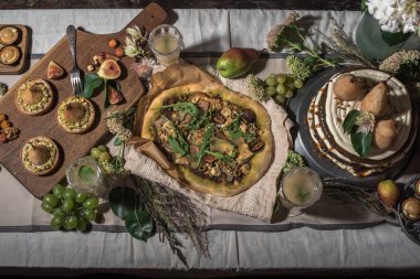 lezzetli kek, armut, pizza ve bahçede şenlikli masaya çiçek tartlets