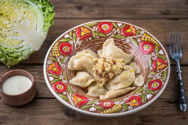 Köfte lahana ve ekşi krema rustik ahşap masa üzerinde renkli plaka 