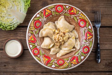 köfte lahana ve ekşi krema ile renkli plaka üstten görünüm rustik ahşap tablo  