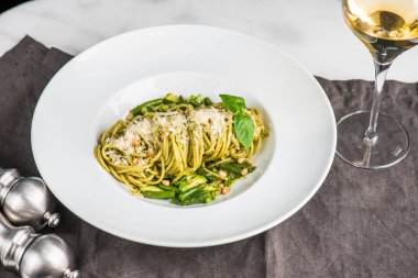 Beyaz şarap bir bardak beyaz tabak İtalyan sebze makarna